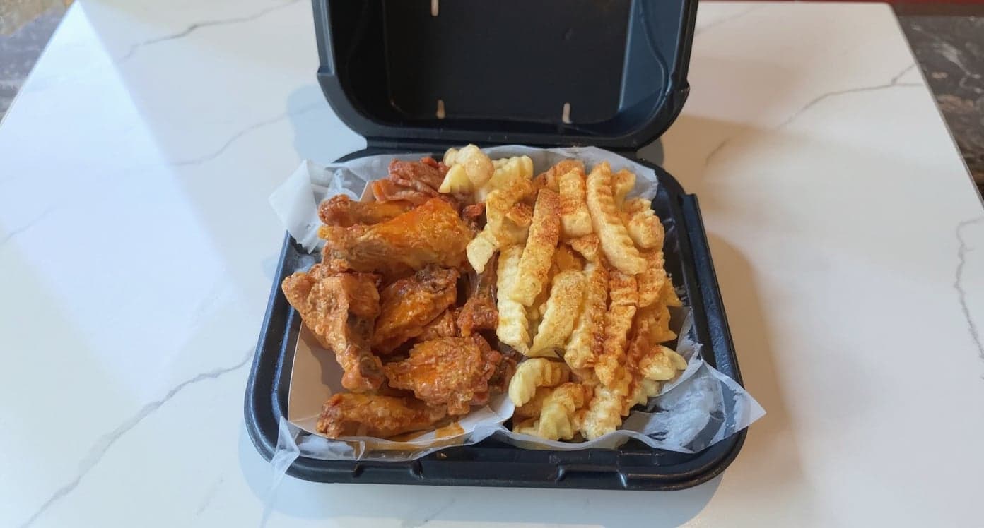 A wing restaurant's own phone photo of wings and fries in a takeout box, before and after enhancement with MenuPhotoLab
